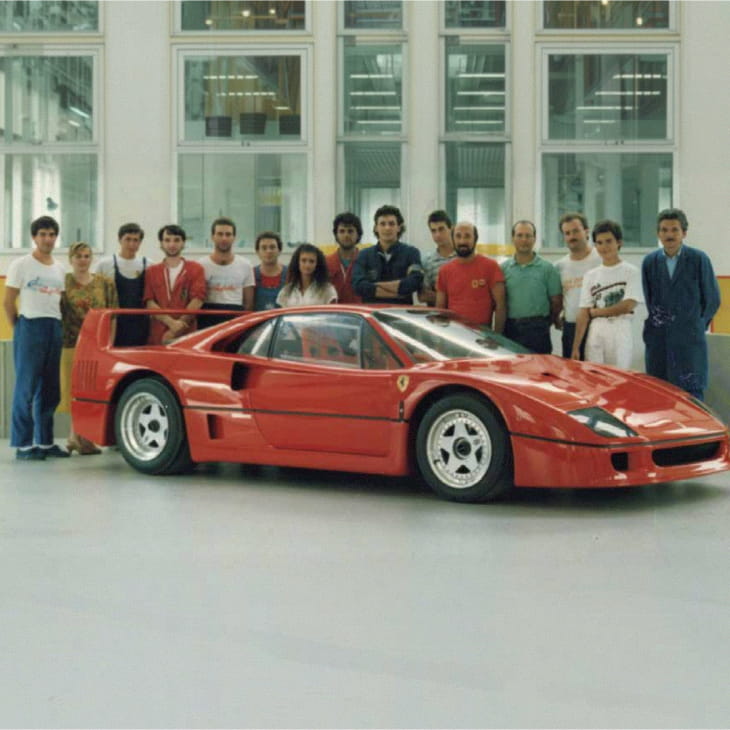 Group photo of the Officina Michelotto team with the red Ferrari F40 in the workshop